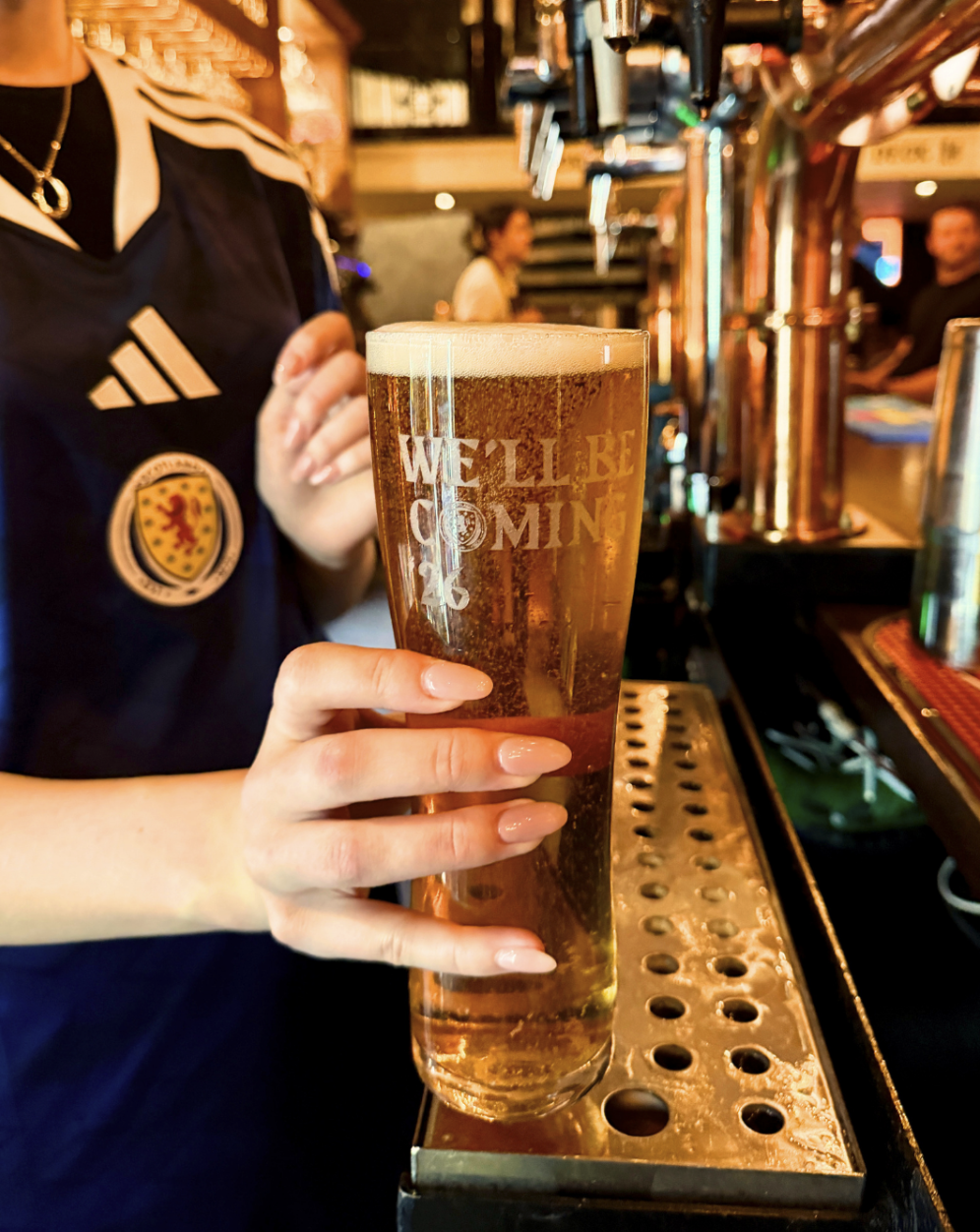Scottish pint of lager at The Barrelman staff at the barrelman holding a pint of lager